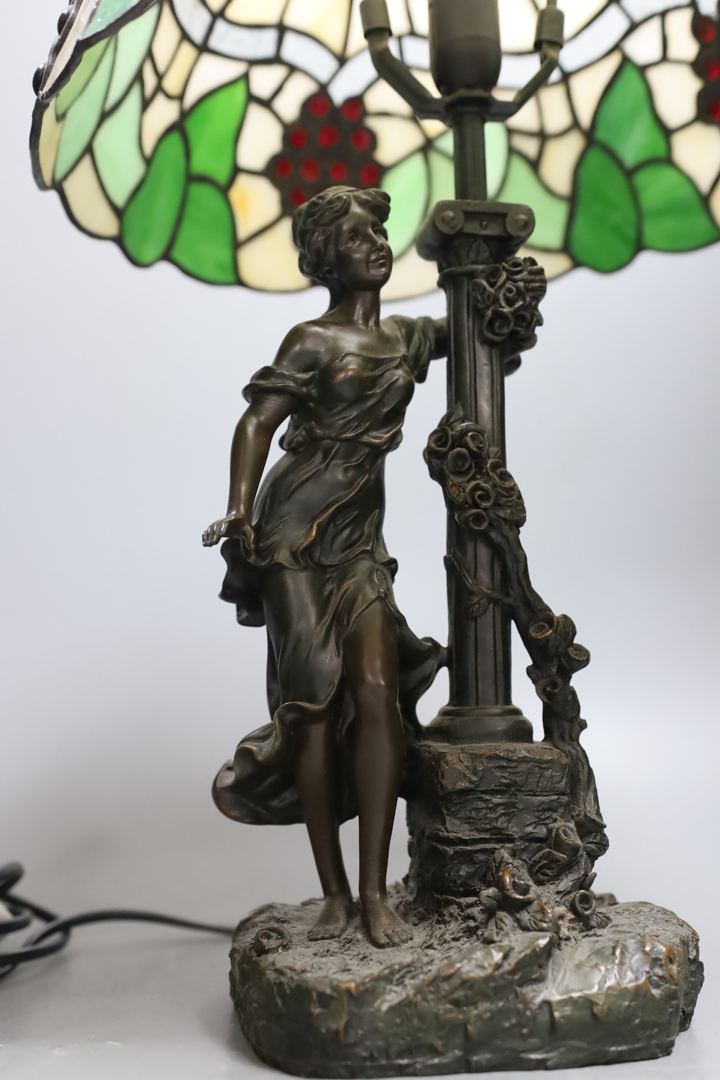 A figural table lamp with Tiffany style shade 47cm